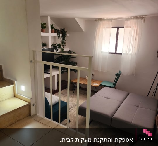 מעקה בטיחות ממתכת בצבע לבן לצד מדרגות בתוך הבית